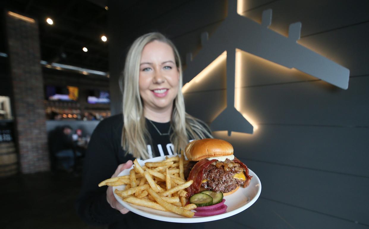 Katie Boughey, executive chef at Flight Bar + Grille restaurant in Huxley, shows the Foundation Burger, a double smash burger with cheddar cheese, thick-cut bacon, caramelized onions and house-made mustard aioli. Flight's burgers are in the Top 10 for Iowa's Best Burger contest.