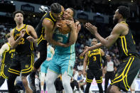 Golden State Warriors guard Moses Moody fouls Charlotte Hornets forward Grant Williams during the second half of an NBA basketball game on Friday, March 29, 2024, in Charlotte, N.C. (AP Photo/Chris Carlson)