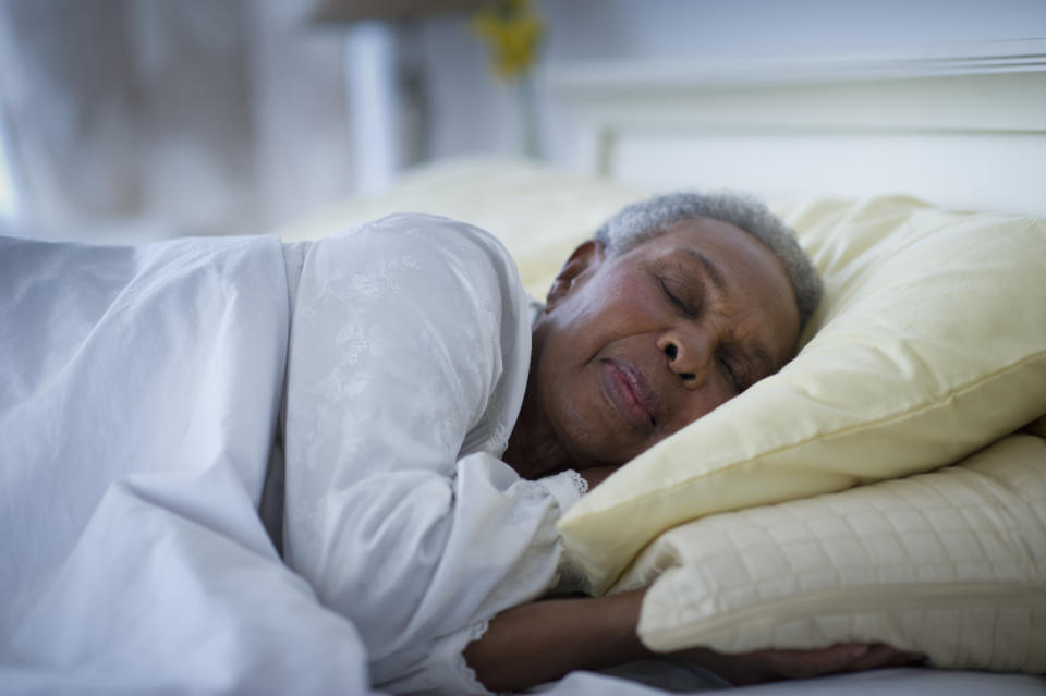 An elderly woman peacefully sleeping on her side in bed