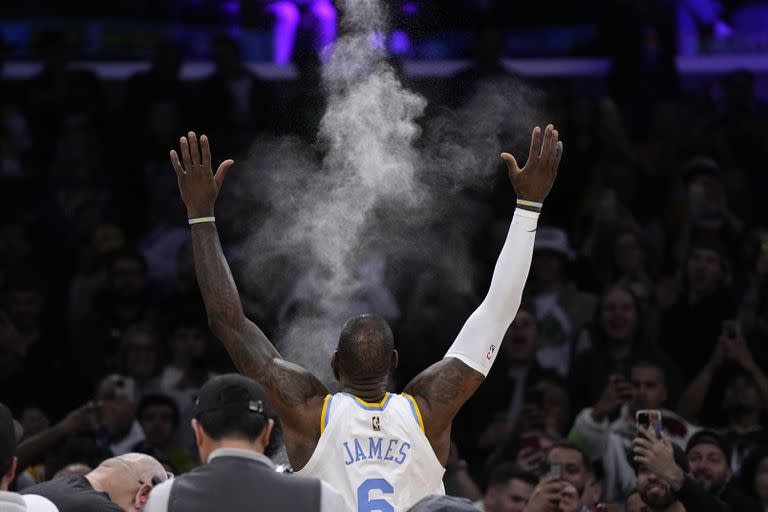 LeBron James arroja polvo al aire antes del inicio del partido de la NBA que enfrentó a su equipo, los Lakers de Los Ángeles, y a los Warriors de Golden State, el 23 de febrero de 2023, en Los Ángeles. (AP Foto/Mark J. Terrill)