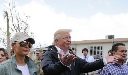 U.S. President Donald Trump gestures as he walks through a neighborhood damaged by Hurricane Maria with first lady Melania Trump as the president tours hurricane damage in Guaynabo, Puerto Rico, U.S., October 3, 2017. REUTERS/Jonathan Ernst