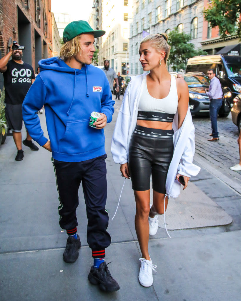 The couple looking at each other as they walk down a busy sidewalk