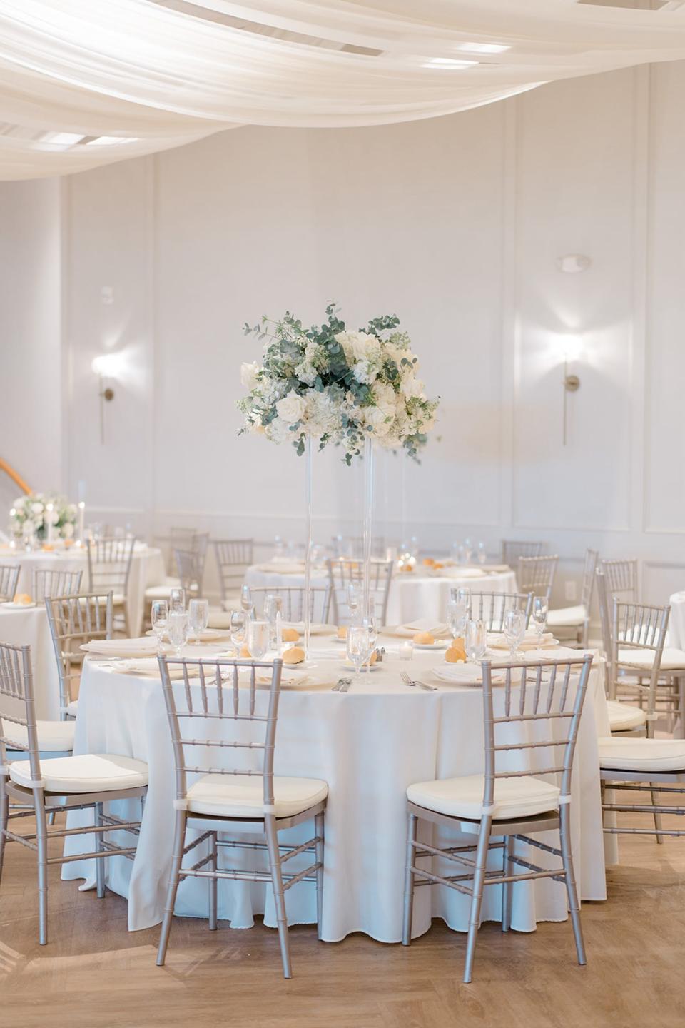 A wedding ballroom with high centerpieces.