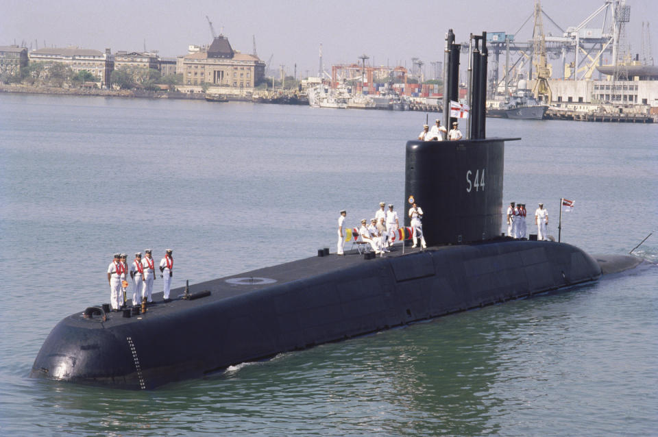 Men stand on the top of a submarine