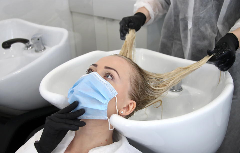 MOSCOW, RUSSIA - JUNE 9, 2020: A worker of the Starlett beauty salon tends to her colleague as they prepare for the reopening. Starting from 9 June, Moscow's beauty and hair salons, which were closed due to the COVID-19 pandemic, resume operation. Valery Sharifulin/TASS (Photo by Valery Sharifulin\TASS via Getty Images)