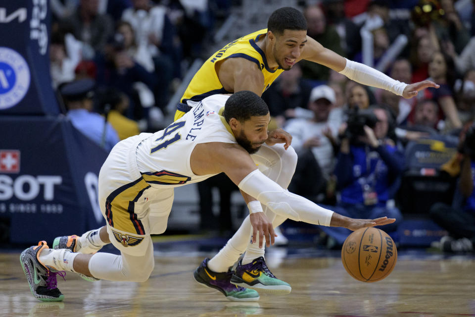 New Orleans Pelicans forward Garrett Temple (41) and Indiana Pacers guard Tyrese Haliburton (0) battle for the ball in the first half of an NBA basketball game in New Orleans, Monday, Dec. 26, 2022. (AP Photo/Matthew Hinton)