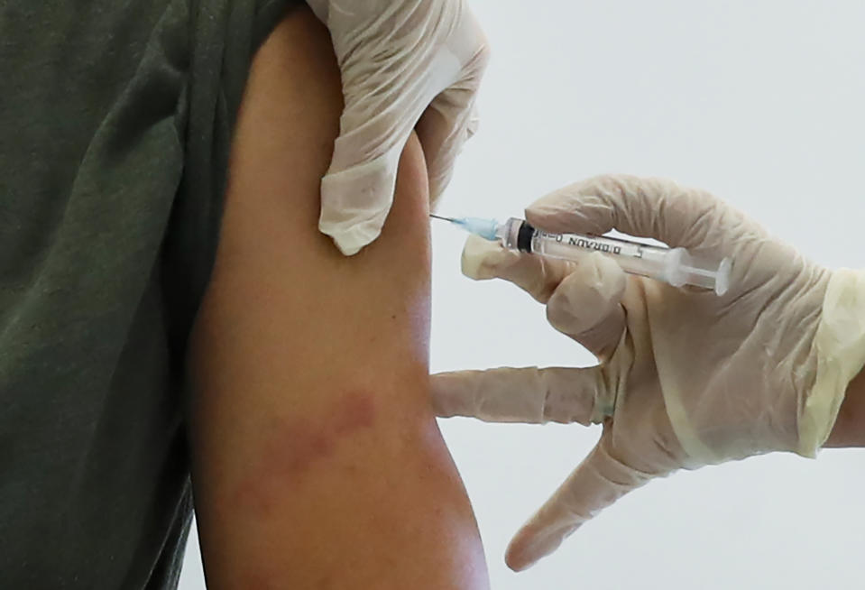 FILE - In this file photo dated Saturday, Dec. 5, 2020, a Russian medical worker administers a shot of Russia's Sputnik V coronavirus vaccine in Moscow, Russia. Belarus on Tuesday Dec. 29, 2020, has announced the start of mass coronavirus vaccinations with the Russian-developed Sputnik V shot, becoming the second country after Russia to roll out the vaccine. (AP Photo/Pavel Golovkin, FILE)