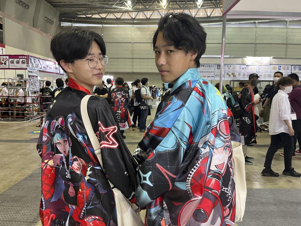 Koyo Mikami, 16, right, shows his Hatsune Miku kimono outfit that he got to attend the celebration at a Tokyo suburb hall, Makuhari Messe, for her 16th birthday, standing with his friend Rio Inoue, 15, in Chiba, east of Tokyo, Japan, Friday, Sept. 1, 2023. Hatsune Miku has always been 16 years old and worn long aqua ponytails. She is Japan's most famous Vocaloid, a computer-synthesized singing voice software that, in her case, comes with a virtual avatar. (AP Photo/Yuri Kageyama)