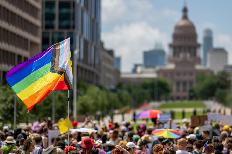 A Pride flag is seen held up in a crowd during preparation for a Queer March to the Texas State Capitol on April 15, 2023 in Austin, Texas. / Credit: BRANDON BELL / Getty Images