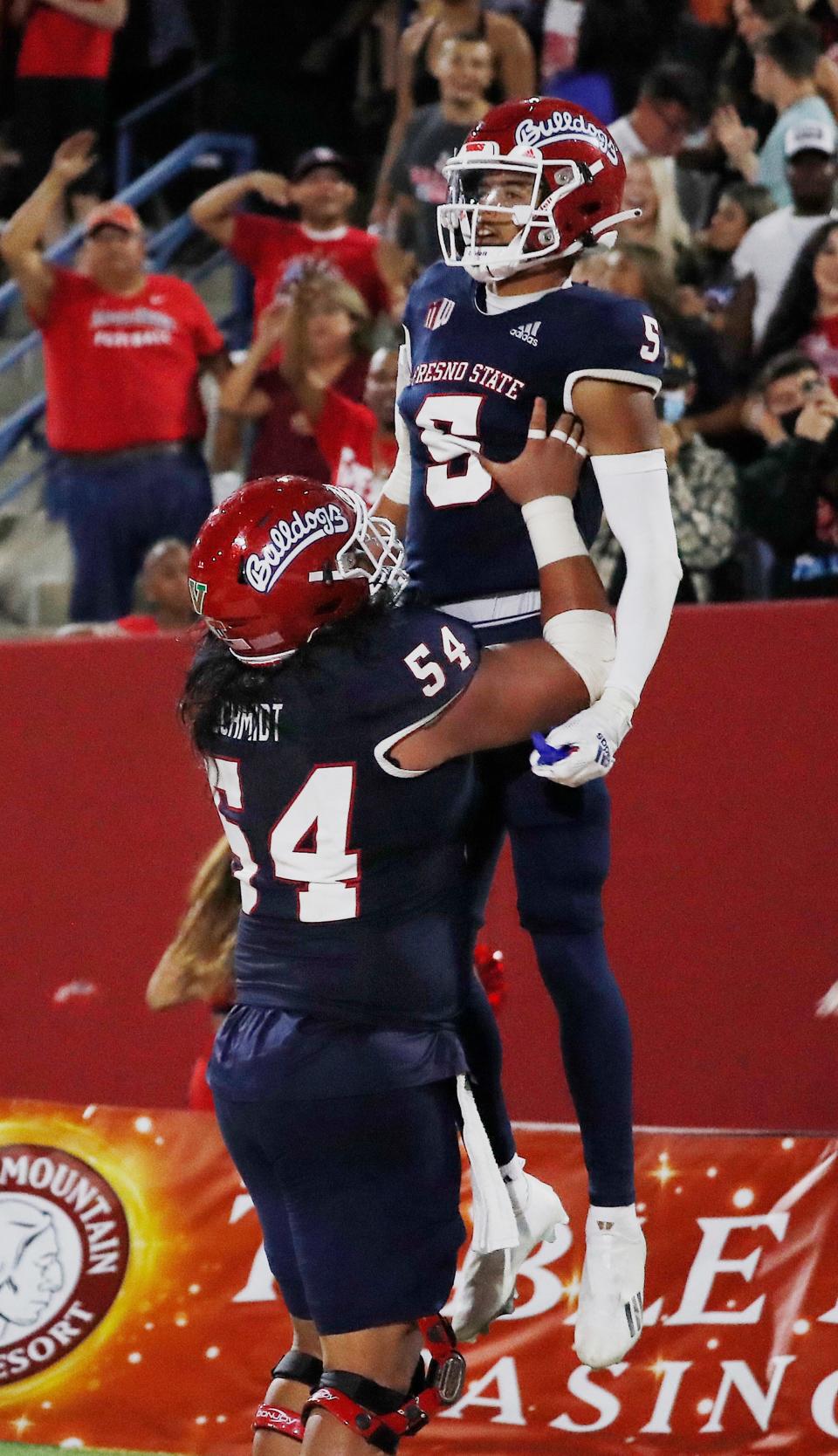 Fresno State offensive lineman Bula Schmidt holds up wide receiver Jalen Cropper after a touchdown against UNLV during the second half of an NCAA college football game in Fresno, Calif., Friday, Sept. 24, 2021.