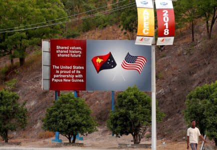 A man walks past a billboard displaying the national flags of the United States and Papua New Guinea a day after the Asia Pacific Economic Cooperation (APEC) forum ended, in Port Moresby, Papua New Guinea, November 19, 2018. REUTERS/David Gray