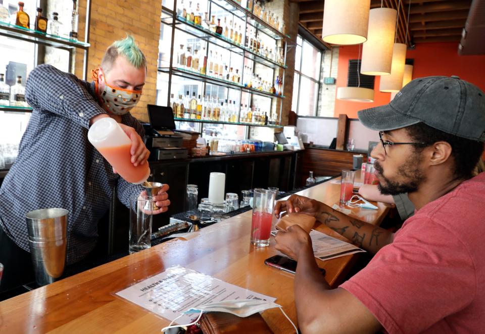 Customer Morgan Williams watches bartender Adam Esser mix a drink as at Blue Bat Kitchen and Tequilaria in the Third Ward.