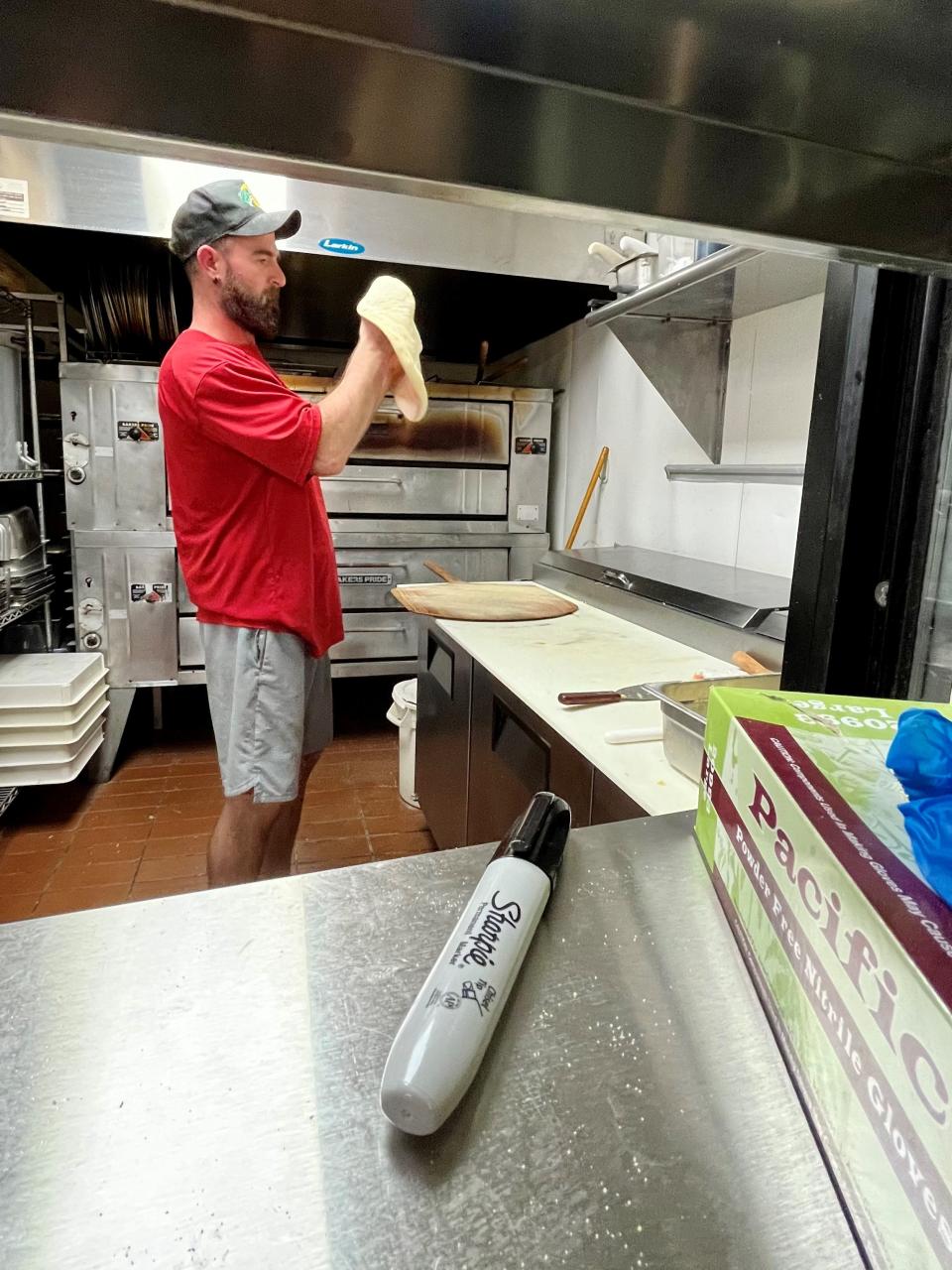 Co-owner Richard Holdridge prepares a pizza order at The Goombah in Cape Coral.