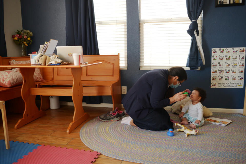 DENVER, CO - MARCH 3 : Flora Montes-Moreno, left, baby-sits 6 month old girl at Little Rascals child care center in Denver, Colorado on Wednesday, March 3, 2021. Flora Montes-Moreno, a child care provider whose business and life have been totally upended during the pandemic. She used to have 11 child care students and now she is down to one client she regularly works with. (Photo by Hyoung Chang/MediaNews Group/The Denver Post via Getty Images)