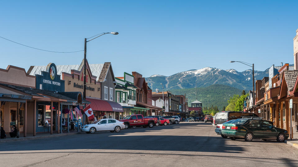 Whitefish, Montana, USA - May 29, 2009 : view of the main street of Whitefish city in Montana with houses, stores, cars.