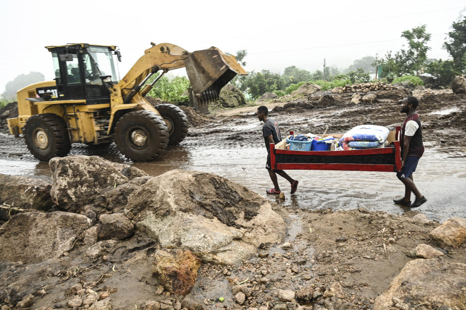 Men transport their salvaged belongings in Chiradzulu, southern Malawi, Friday March 17, 2023. Authorities are still getting to grips with the scale of Cyclone Freddy's destruction in Malawi and Mozambique since late Saturday, with over 300 people confirmed dead and several hundreds still displaced or missing. (AP Photo/Thoko Chikondi)