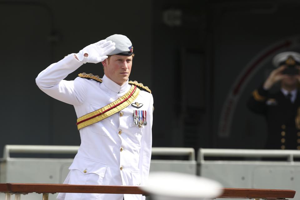 Britain's Prince Harry salutes the troops at Garden Island during the International Fleet Review in Sydney