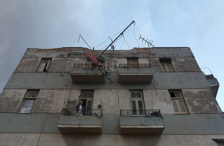 People stand on a balcony after a tornado ripped through a neighbourhood in Havana, Cuba January 28, 2019. REUTERS/Fernando Medina