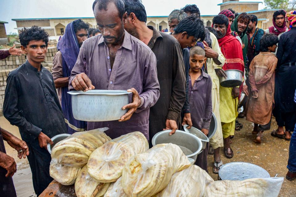 Cyclone evacuees receive food near a temporary shelter set at a school in Pakistan’s coastal area in Sujawal in Sindh province (AFP via Getty Images)