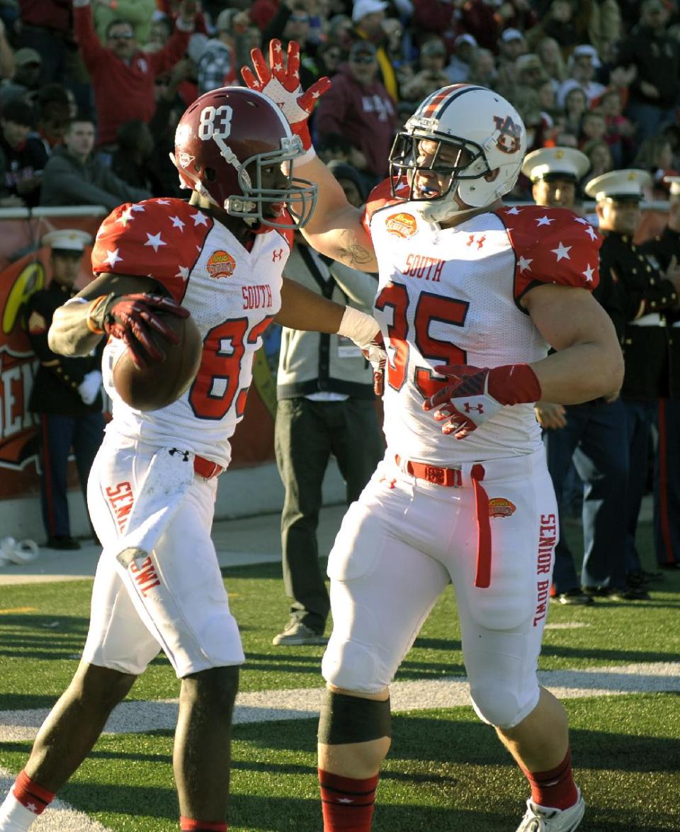 South wide receiver Kevin Norwood (83), of Alabama, celebrates with fullback Jay Prosch (35), of Auburn, following a touchdown reception during the first quarter of the Senior Bowl NCAA college football game on Saturday, Jan. 25, 2014, in Mobile, Ala. (AP Photo/G.M. Andrews)