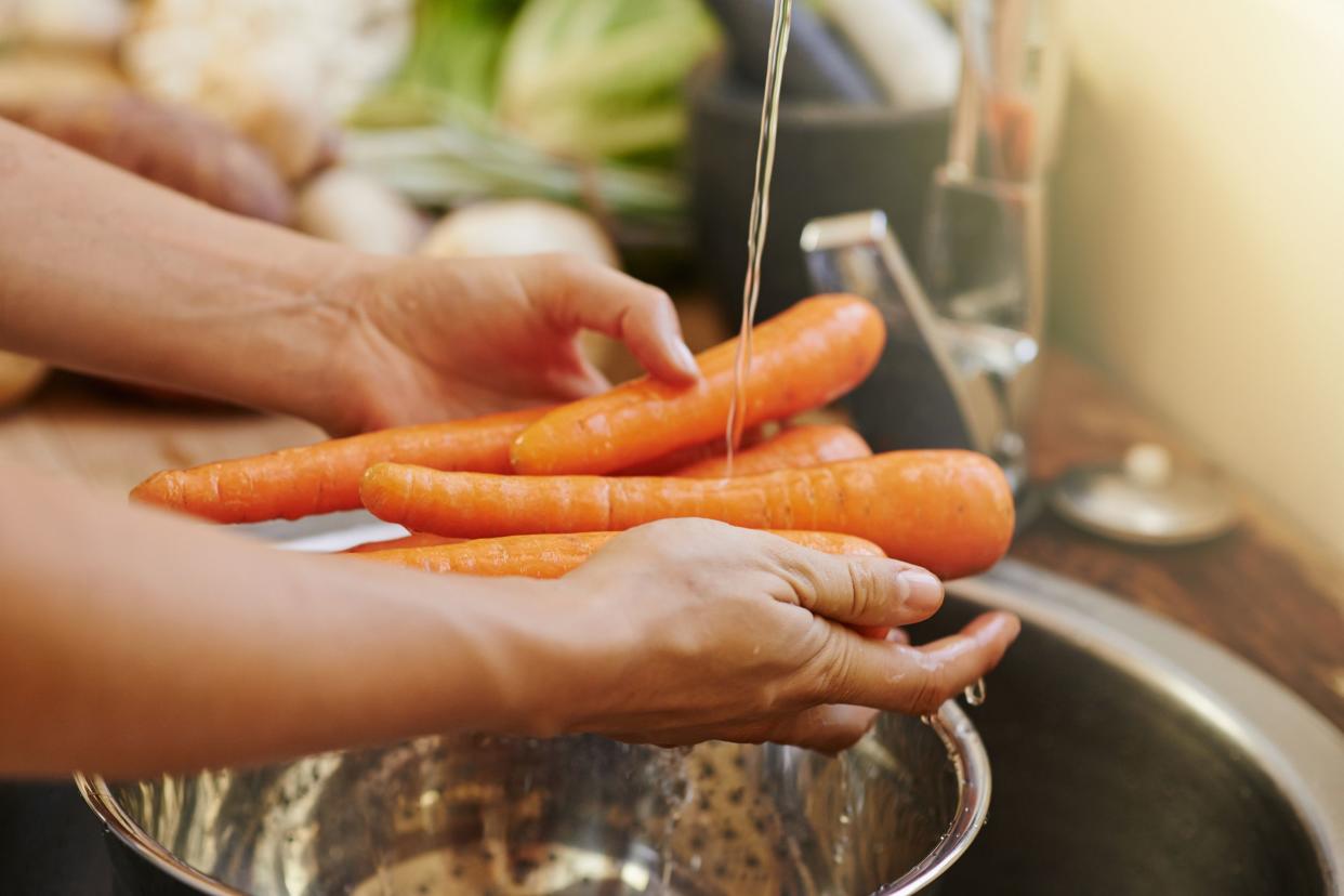 hand washing carrots in sink