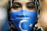 A woman wears a face mask reading 'Free Uyghurs' as she attends a protest during the visit of Chinese Foreign Minister Wang Yi in Berlin, Germany, Tuesday, Sept. 1, 2020. German Foreign Minister Heiko Maas meets his Chinese counterpart at the foreign ministry guest house Villa Borsig for bilateral talks. (AP Photo/Markus Schreiber)