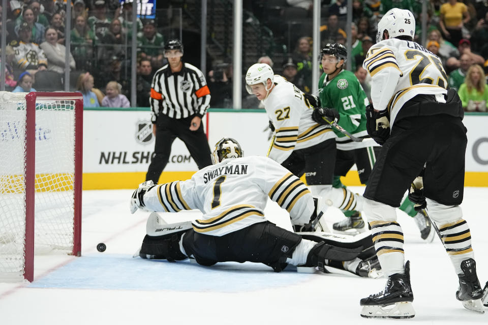 A shot by the Dallas Stars misses the goal of Boston Bruins goaltender Jeremy Swayman (1) during the first period of an NHL hockey game, Monday, Nov. 6, 2023, in Dallas. (AP Photo/Julio Cortez)