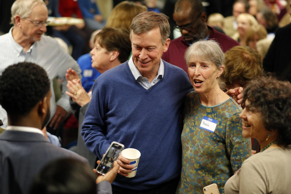 Former Colorado Gov. John Hickenlooper, center, poses for a photo with a local resident at the Story County Democrats' annual soup supper fundraiser, Saturday, Feb. 23, 2019, in Ames, Iowa. (AP Photo/Charlie Neibergall)