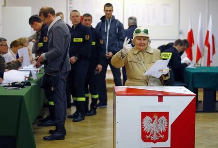 A woman reacts as she prepares to cast her ballot at a polling station in Warsaw, Poland October 25, 2015. REUTERS/Pawel Kopczynski