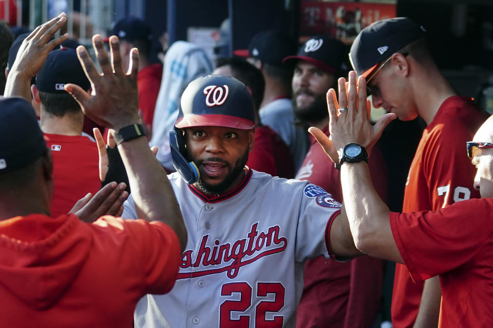 Washington Nationals' Dominic Smith (22) celebrates in the dugout after scoring on a Jacob Young two-run base hit in the ninth inning of a baseball game against the Atlanta Braves, Sunday, Oct. 1, 2023, in Atlanta. (AP Photo/John Bazemore)