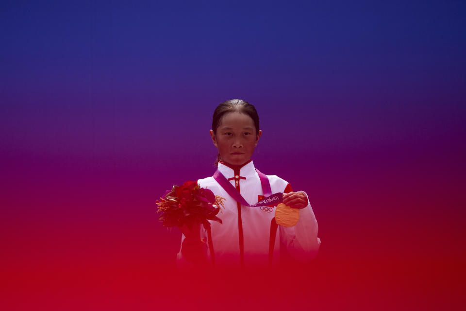 13-year-old Cui Chenxi, from China, celebrates with her gold medal during the awards ceremony for skateboarding women's street final at the 19th Asian Games in Hangzhou, China, Wednesday, Sept. 27, 2023. (AP Photo/Louise Delmotte)