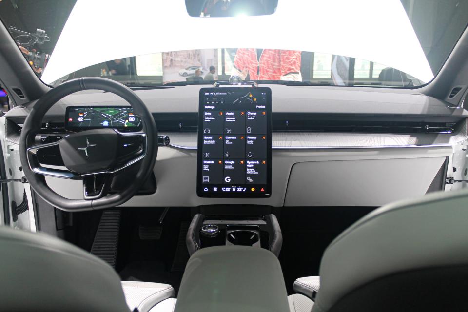 The steering wheel, screen, and dashboard of the Polestar 3 electric SUV, viewed from its back seat.