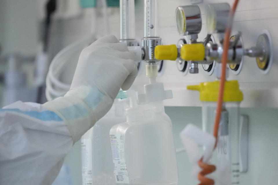 Medical staff adjust the oxygen level for a patient at the COVID-19 ICU unit of the Marius Nasta National Pneumology Institute in Bucharest, Romania, Thursday, Sept. 23, 2021. Daily new coronavirus infections in Romania, a country of 19 million, have grown exponentially over the last month, while vaccine uptake has declined to worrying lows. Government data shows that 91.5% of COVID-19 deaths in Romania between Sept. 18-23 were people who had not been vaccinated. (AP Photo/Vadim Ghirda)