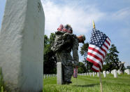 <p>A soldier of the 3rd U.S. Infantry Regiment (the Old Guard) places flags in front of the graves at Arlington National Cemetery outside of Washington, D.C., May 26, 2016. (Reuters/Joshua Roberts) </p>