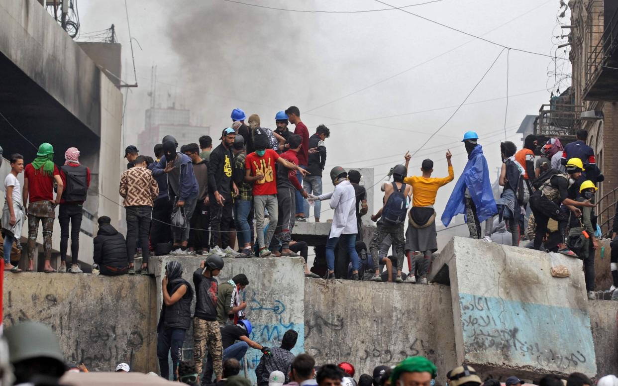 Iraqi protesters clash with Iraqi security forces in al-Rasheed Street in Baghdad during ongoing anti-government demonstrations against corruption on Thursday - AFP