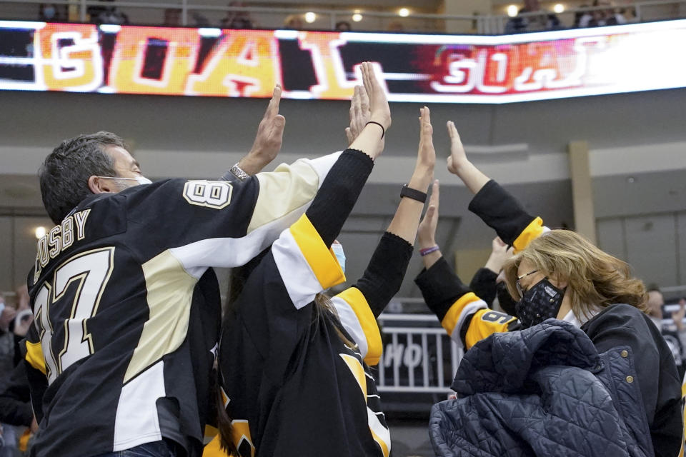 Pittsburgh Penguins fans celebrate the second goal of the period by Pittsburgh Penguins' Kasperi Kapanen (42) against the Philadelphia Flyers during the second period of an NHL hockey game, Tuesday, March 2, 2021, in Pittsburgh. It was the first game a limited number of fans were allowed to attend in Pittsburgh after some COVID 19 crowd restrictions were lifted by the state earlier this week. (AP Photo/Keith Srakocic)