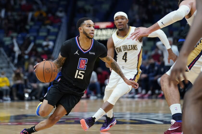 Los Angeles Clippers guard Xavier Moon (15) drives the lane past New Orleans Pelicans guard Devonte' Graham.