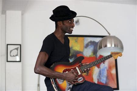 Nigerian musician Keziah Jones plays on a guitar during an interview with Reuters at his home in Lagos February 25, 2014. REUTERS/Akintunde Akinleye