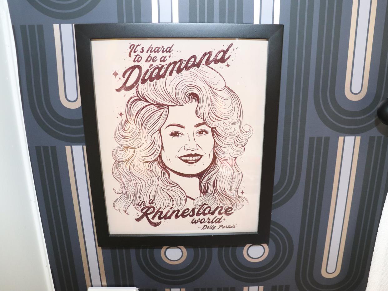 A Dolly Parton poster reading "It's hard to be a diamond in a rhinestone world."