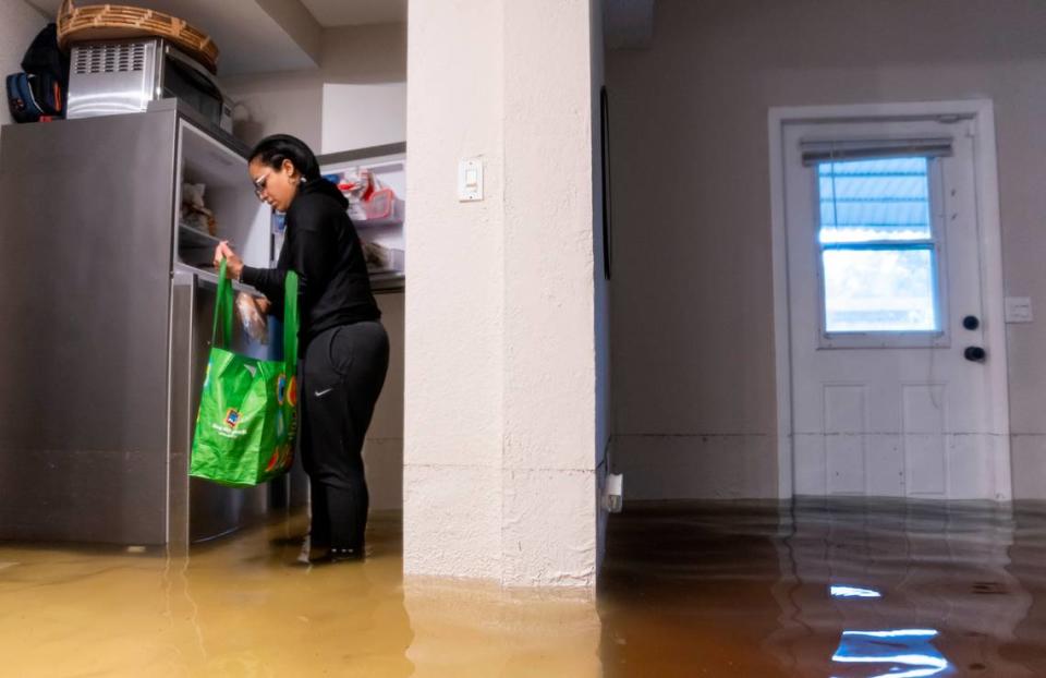 Denis Mendez, 32, packs food while inside their partially submerged home in the Edgewood neighborhood on Thursday, April 13, 2023, in Fort Lauderdale, Fla. A torrential downpour severely flooded streets, partially submerging houses and cars across South Florida.