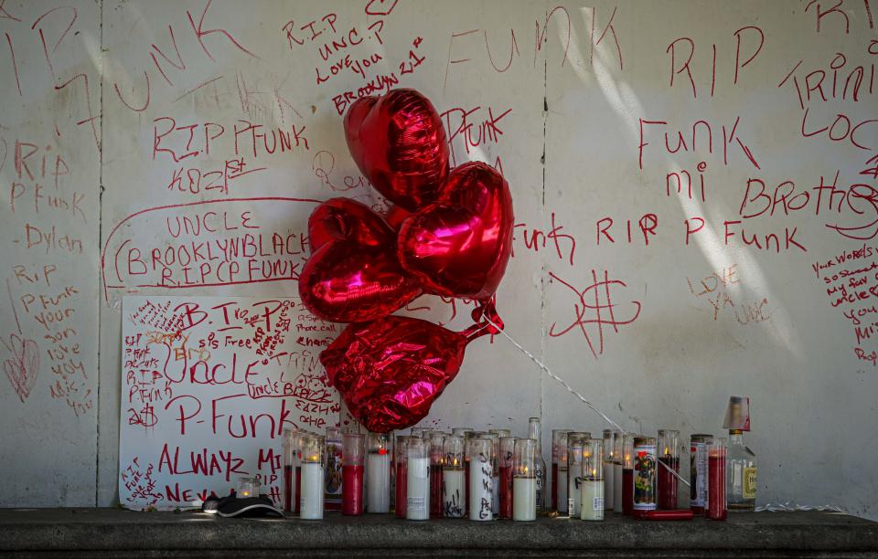 Heart-shaped balloons and candles mark the spot at the entrance to Prosp[ect Park where 47-year-old Paul "P-Funk" Pinkney was murdered over the past weekend Monday, Aug. 17, 2020, in New York. President Donald Trump is again threatening to send federal agents to New York City if local authorities don't stop a surge of violence that has left seven people dead and more than 50 people shot since Friday. (AP Photo/Bebeto Matthews)
