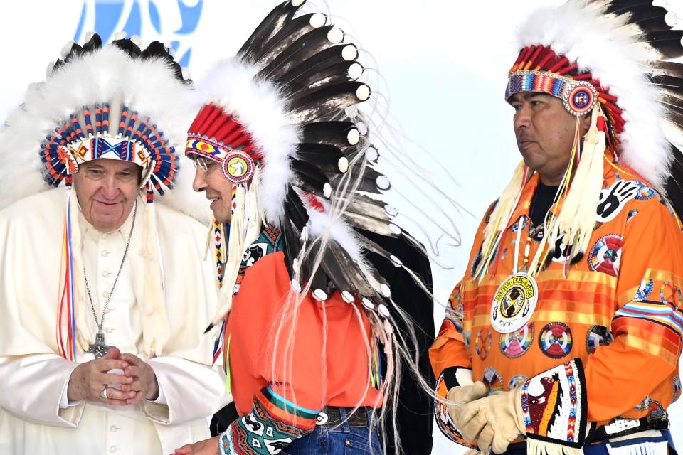 TOPSHOT - Pope Francis wears a headdress presented to him by Indigenous leaders at Muskwa Park in Maskwacis, Alberta, Canada, on July 25, 2022. - Pope Francis will make a historic personal apology Monday to Indigenous survivors of child abuse committed over decades at Catholic-run institutions in Canada, at the start of a week-long visit he has described as a "penitential journey." (Photo by Patrick T. FALLON / AFP) (Photo by PATRICK T. FALLON/AFP via Getty Images) ORIG FILE ID: AFP_32FG2XF.jpg