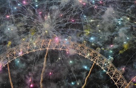 Fireworks explode around the London Eye wheel during New Year celebrations in central London January 1, 2014. REUTERS/Toby Melville