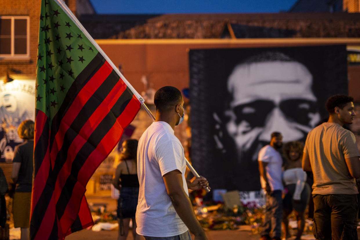 A man carries a Black Liberation flag through a Juneteenth celebration at the memorial for George Floyd outside Cup Foods on June 19, 2020 in Minneapolis, Minnesota. (Photo by Stephen Maturen/Getty Images)