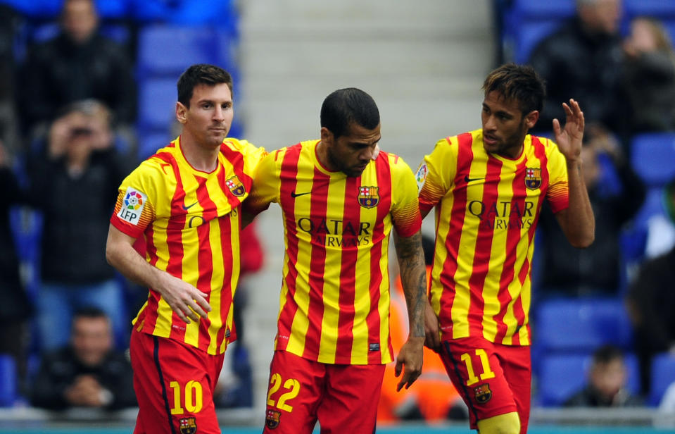 FC Barcelona's Lionel Messi, left, celebrates after scoring a penalty with teammates Neymar, right, and Daniel Alves, center, during a Spanish La Liga soccer match against Espanyol at Cornella-El Prat stadium in Cornella Llobregat, Spain, Saturday, March 29, 2014. (AP Photo/Manu Fernandez)