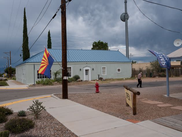 An elderly man walks past a building flying the Arizona flag along with a Trump 2024 flag in Tombstone, Arizona. (Photo: Molly Peters for HuffPost)