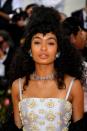 <p>Style natural voluminous curls like Yara Shahidi by gathering some sections for a top knot and letting the rest fall down. </p>