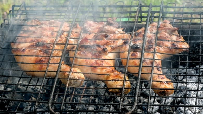 Chicken legs sandwiched between grill grates