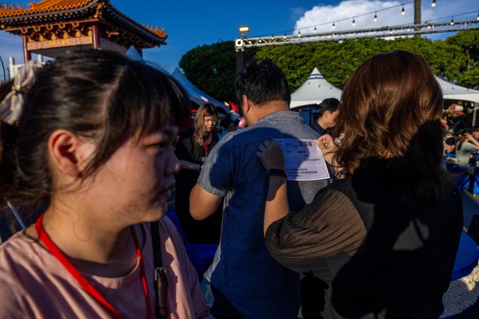 People hold up name tags at a singles event.