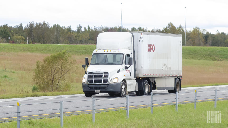 A white XPO day cab pulling a white LTL trailer on a highway